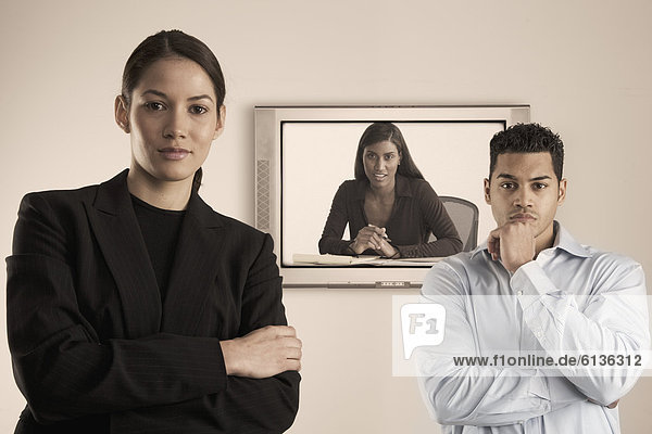 Portrait of business people in front of monitor