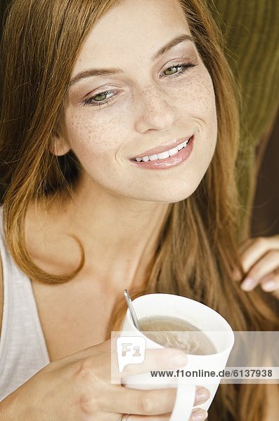 Smiling young woman drinking tea
