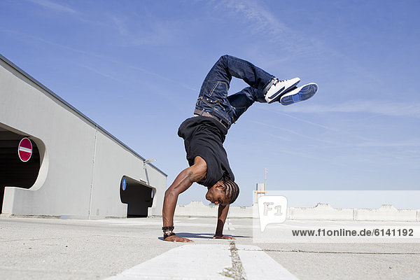 Man doing handstand on rooftop