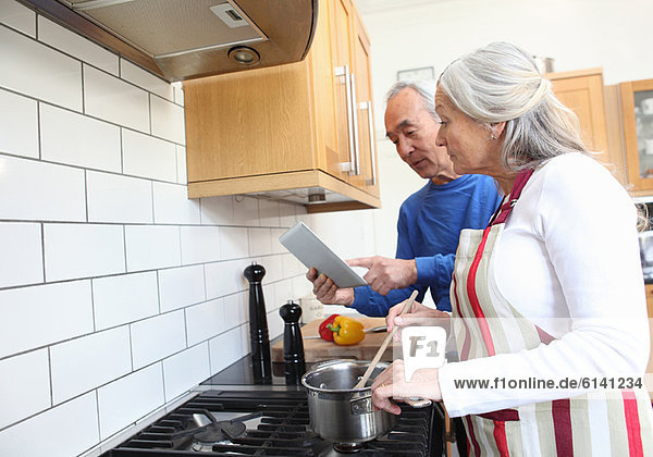 Older couple cooking together in kitchen