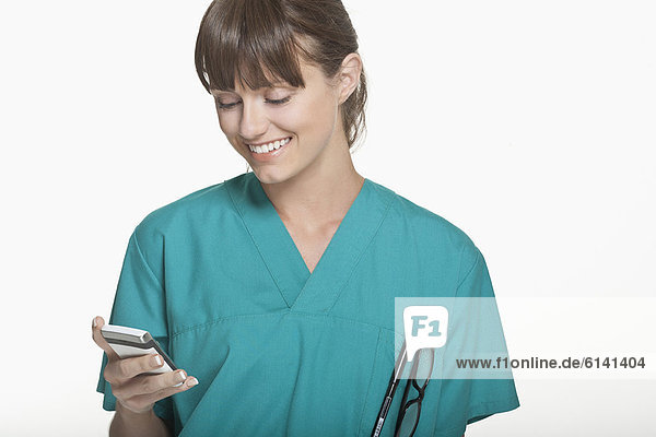 Lächelnder Chirurg mit dem Handy