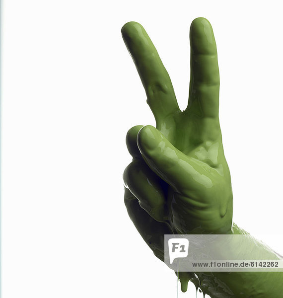 Grün bemalte Hand macht Friedenszeichen