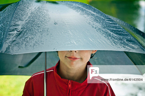 Junge unter einem Regenschirm