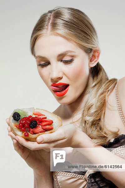 Junge Frau isst frische Obsttorte