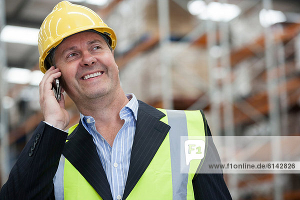 Man on cell phone in warehouse  portrait