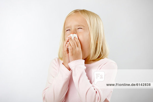 Girl with cold blowing nose