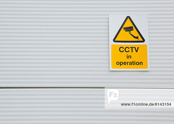 Surveillance camera sign on warehouse door