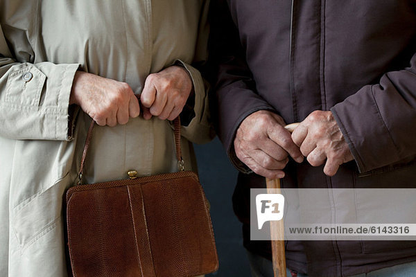 Älterer Mann mit Gehstock  ältere Frau mit Handtasche