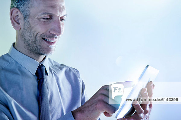 Geschäftsmann mit digitalem Tablett mit Beleuchtung