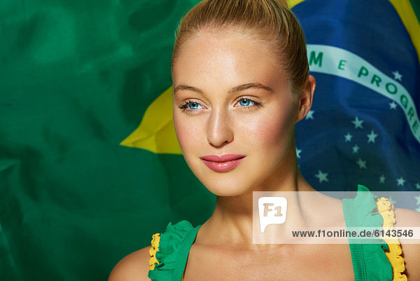 Junge Frau vor brasilianischer Flagge