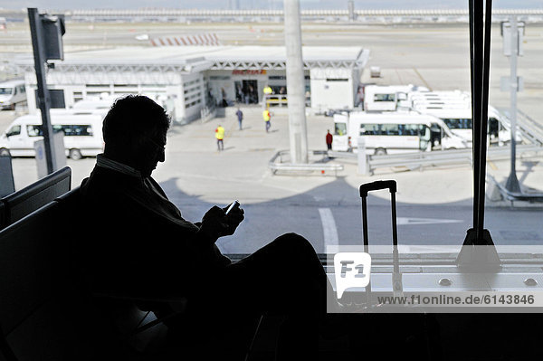 Fluggast mit Handy im Gegenlicht  Wartehalle  Flughafen San Jose  Costa Rica  Mittelamerika