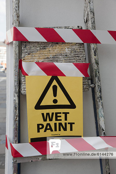 '''Wet paint''  Englisch für ''frisch gestrichen''  Schild an einer Leiter'