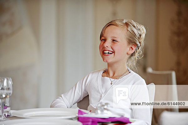 Girl  9 years  smiling at the dinner table on her First Communion day  Muensterland region  North Rhine-Westphalia  Germany  Europe