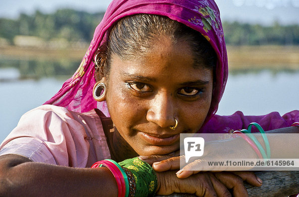 Porträt einer jungen Frau die auf den Salzfeldern von Diu arbeitet  Indien  Asien