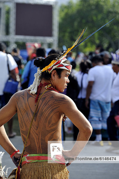 Junger indigener Mann mit Tattoos und Federschmuck während des UN-Nachhaltigkeitsgipfels Rio+20 in Rio de Janeiro  Brasilien  Südamerika
