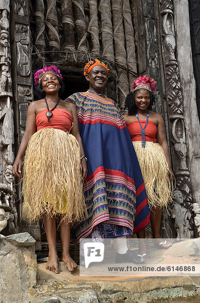 König Fon Abumbi II. mit zweien seiner Lieblingsfrauen vor dem zentralen Achum-Heiligtum an seinem Herrschersitz  dem Palast von Bafut  eines der traditionellen Königreiche Kameruns  bei Bamenda  Nordwest-Kamerun  Zentralafrika  Afrika