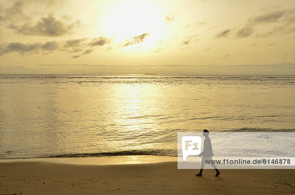 Mann spaziert im Sonnenuntergang den Strand entlang  bei Kribi  Kamerun  Zentralafrika  Afrika
