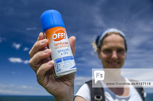 Junge Frau hält Moskito-Schutzspray in der Hand  Neuseeland  Ozeanien