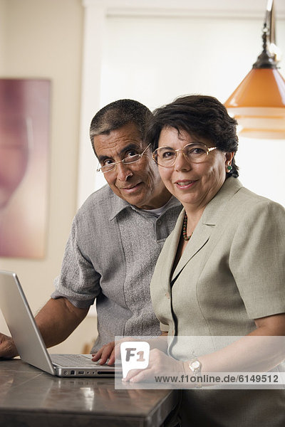 Portrait of mature couple with laptop