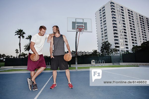 Caucasian men standing on basketball court