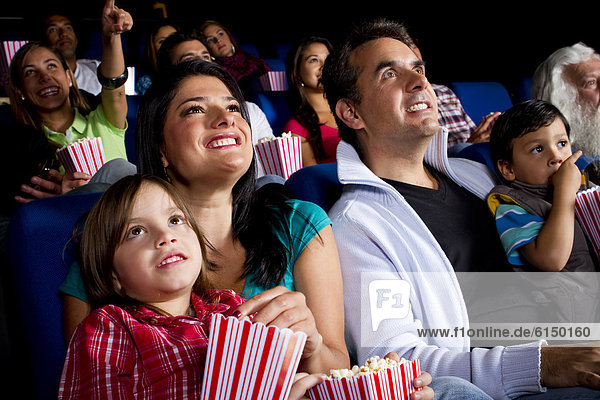 Hispanic family watching film in movie theater