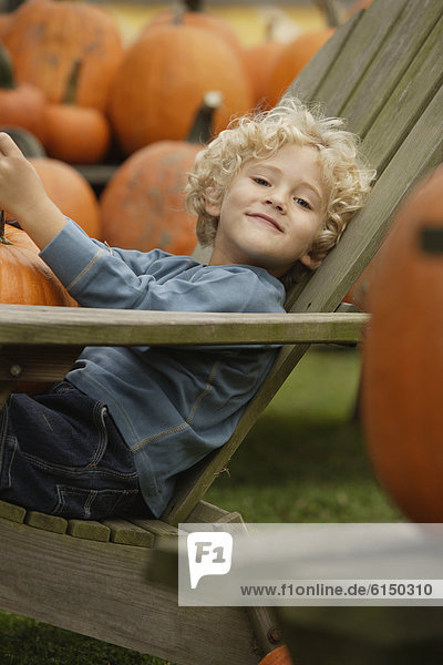 Boy in chair holding pumpkin