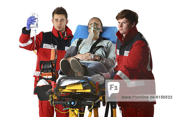 Feuerwehr Rettungsdienst Rettungssanitäter Rettungsassistenten und Patientin wird beatmet bekommt eine Infusion auf fahrbarer Krankentrage Berufsfeuerwehr Essen Essen Nordrhein-Westfalen Deutschland Europa