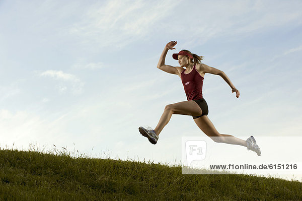 Caucasian runner running in field