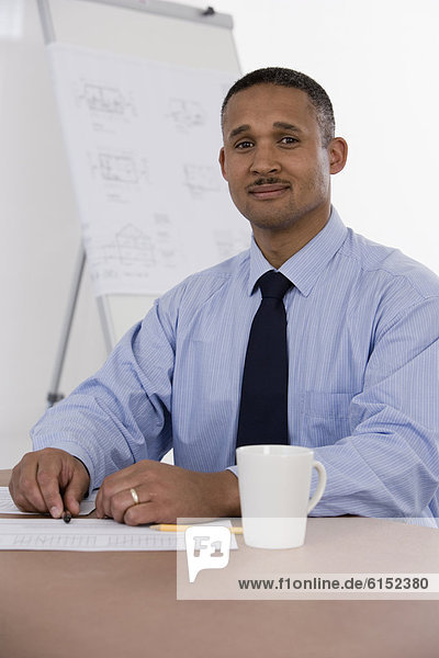 African businessman at table with paperwork