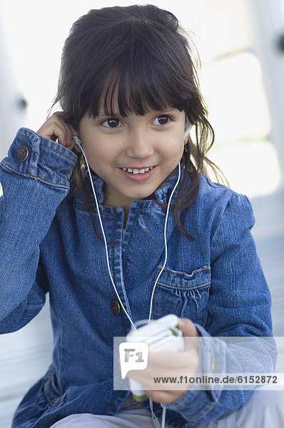 Hispanic girl listening to mp3 player