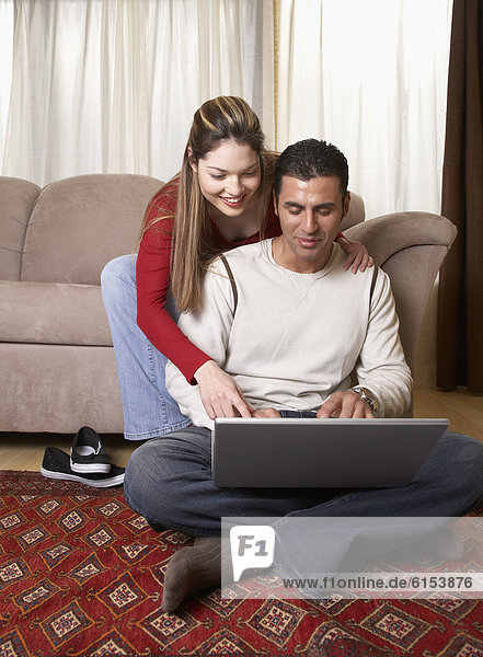 Hispanic couple looking at laptop