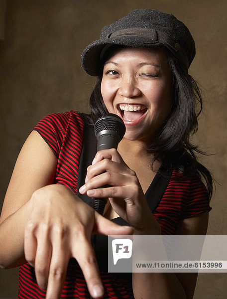 Asian woman singing with microphone