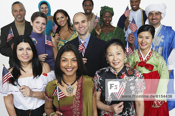 Multi-ethnic people in traditional dress holding American flags