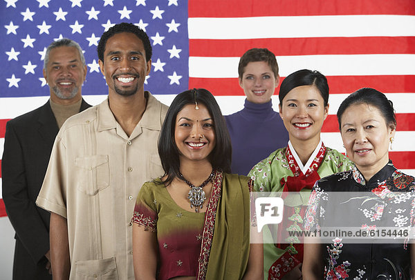 Multi-ethnic people standing in front of American flag
