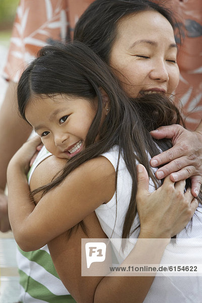 Asian mother hugging daughter