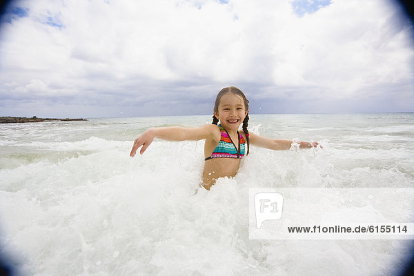 Asian girl playing in surf