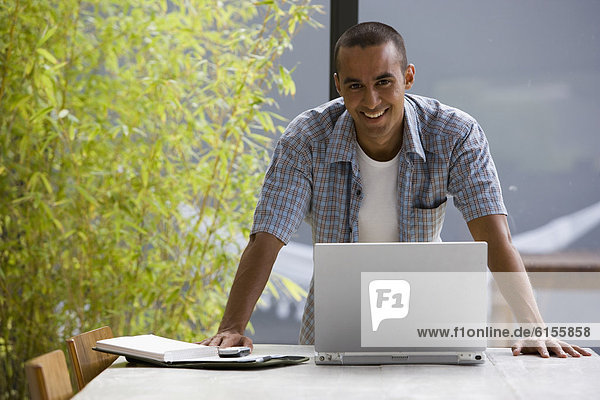 Portrait of young man with laptop
