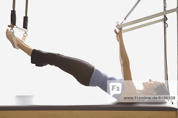 Woman stretching on exercise equipment