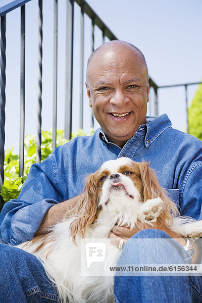 Senior Senioren Mann umarmen Hund amerikanisch