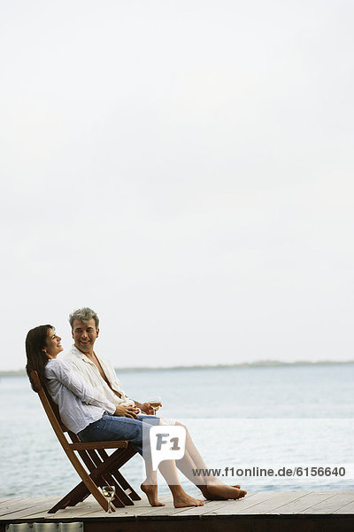 South American couple sitting on dock
