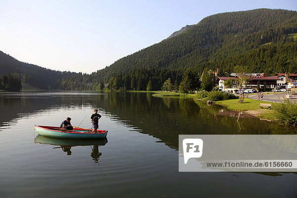 Young fishermen in a rowing boat on lake Spitzingsee  a mountain lake  1084 meters above sea level  Mangfall mountains  Upper Bavaria  Bavaria  Germany  Europe