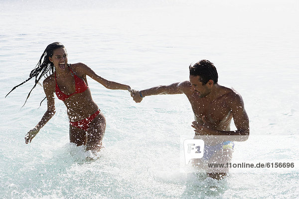 South American couple running in water