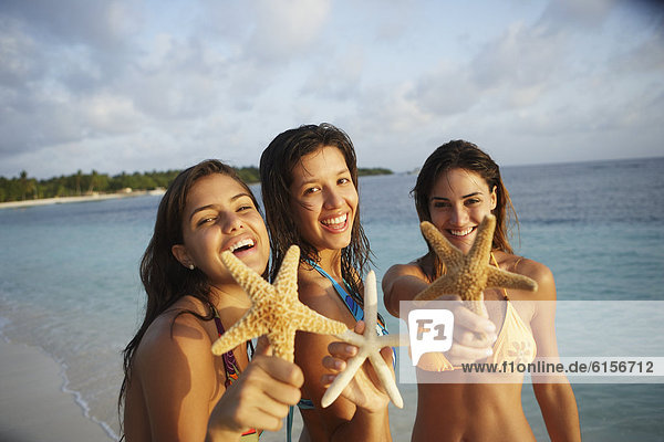 South American women holding starfish