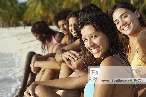 South American friends sitting on beach