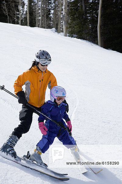 Asian mother and daughter skiing