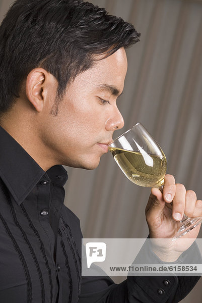 Hispanic man drinking wine