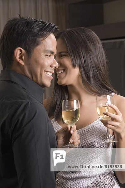 Hispanic couple drinking wine