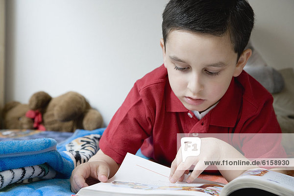 Hispanic boy reading book