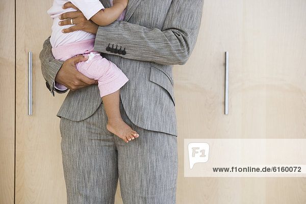 African American businesswoman holding baby