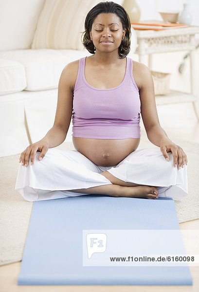 Pregnant African American woman practicing yoga